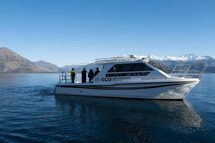Ein Öko-Tour-Boot gleitet mit Passagieren an Bord über einen ruhigen See.